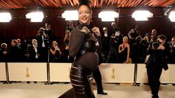 Rihanna tia untuk menghadiri Academy Awards ke-95 atau Oscar 2023 di Teater Dolby di Hollywood, California pada Minggu, 12 Maret 2023, waktu setempat. Rihanna yang tengah mengandung buah hati keduanya ini mengenakan gaun tersebut di atas bodysuit turtleneck tipis. (Photo by VALERIE MACON / AFP)
