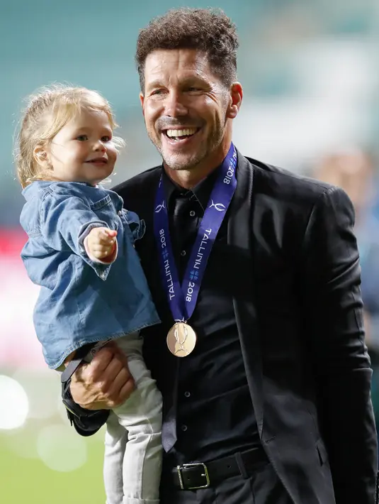 Pelatih Atletico Madrid, Diego Simeone menggendong putrinya Francesca saat berselebrasi meraih juara Piala Super Eropa setelah mengalahkan Real Madrid 4-2 di Lillekula Stadium di Tallinn, Estonia, (15/8). (AP Photo/Pavel Golovkin)