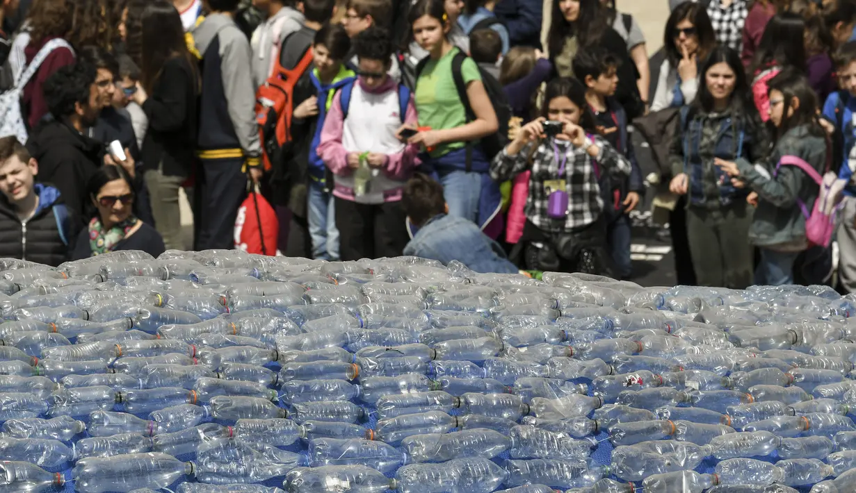 Anak-anak mengambil gambar patung paus raksasa, Plasticus yang dipajang di depan Auditorium Parco della Musica, Roma, Italia, Senin (16/4). Plasticus dibuat untuk meningkatkan kesadaran tentang masalah pencemaran plastik di laut. (Andreas SOLARO/AFP)