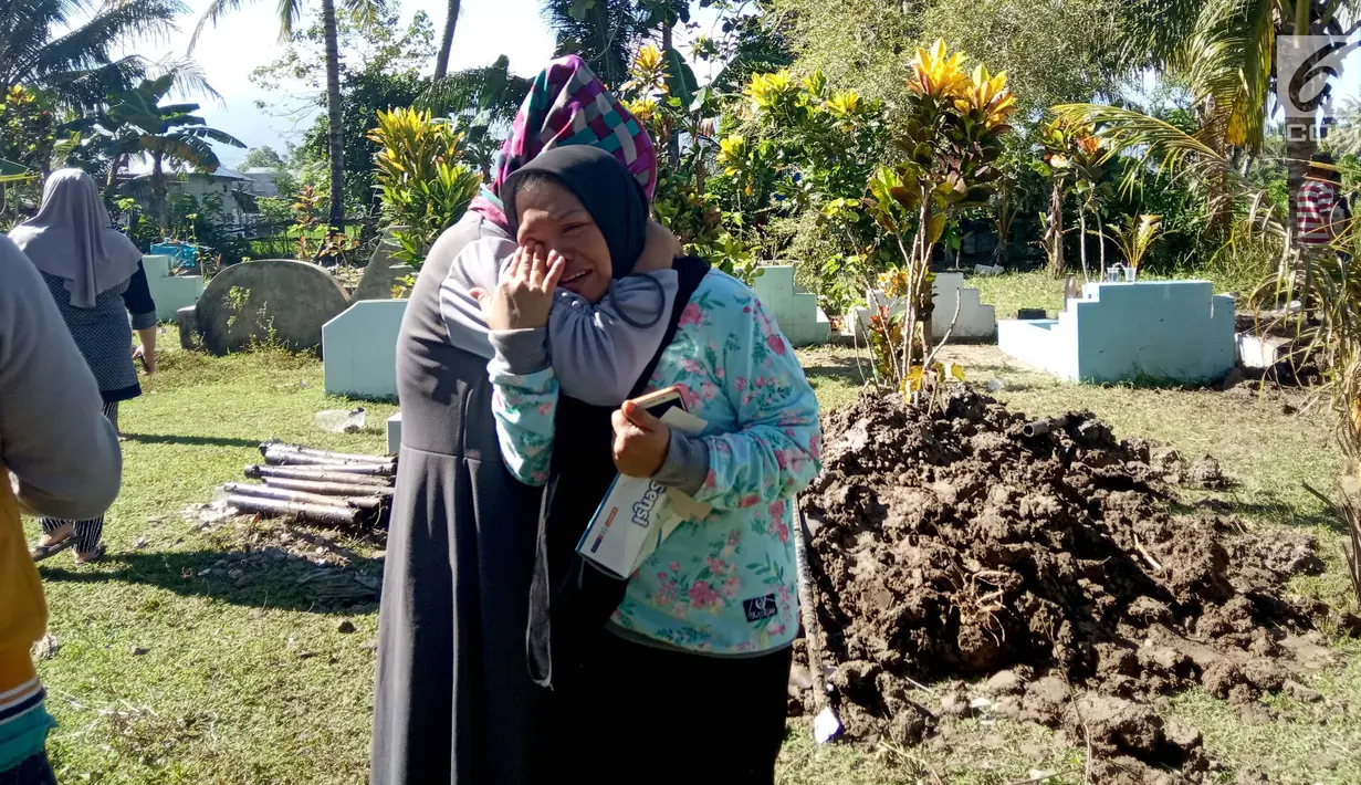 Seorang wanita menangis menyaksikan pemindahkan jasad dari kuburan di Desa Toto Selatan, Kabupaten Bone Bolango, Gorontalo, Sabtu (12/1). Pemindahan kuburan berlangsung aman dan lancar. (Liputan6.com/Arfandi Ibrahim)