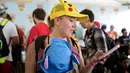 Peserta asal Miami menggendong anaknya sambil berusaha mendapatkan pokemon dalam Festival Pokemon Go, di Giant Park, Chicago, Sabtu (22/7). Festival ini dihadiri oleh penggemar game fenomenal Pokemon Go dari berbagai kota. (AP/Erin Hooley)