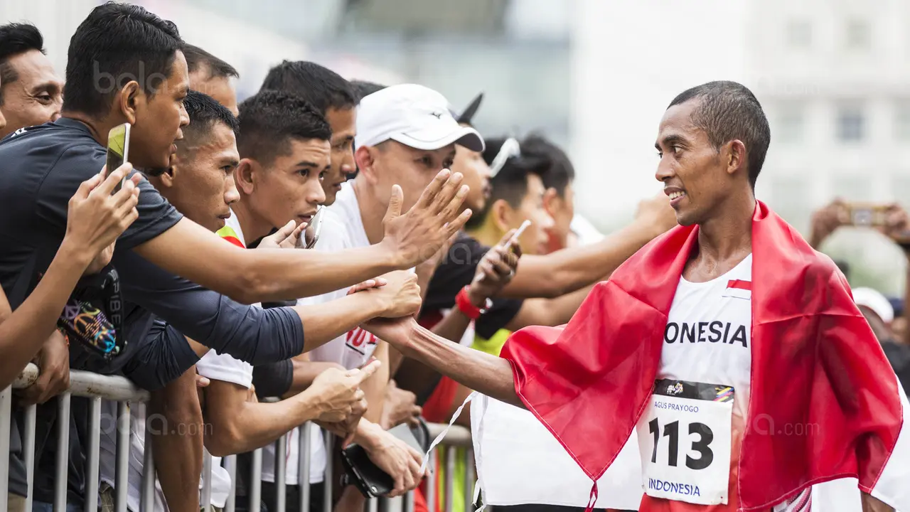 Pelari Indonesia, Agus Prayogo, menyapa suporter usai tampil pada nomor maraton SEA Games 2017 di Putrajaya, Kuala Lumpur, Sabtu (19/8/2017). Agus meraih medali perak dengan waktu dua jam 27 menit 16 detik. (Bola.com/Vitalis Yogi Trisna)