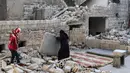 Keluarga Tareq Abu Ziad bersiap untuk berbuka puasa di tengah reruntuhan rumah mereka yang hancur setelah serangan militer pasukan pemerintah dan sekutunya di Kota Ariha, Provinsi Idlib, Suriah, Senin (4/5/2020). Muslim Suriah melewati Ramadan tahun ini masih dalam kondisi perang. (AAREF WATAD/AFP)