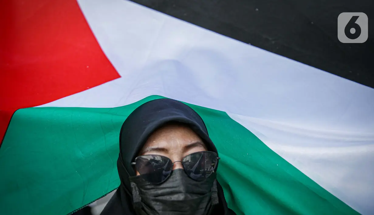 Massa Gerakan Pekerja Muslim Indonesia (GPMI) melakukan aksi solidaritas untuk Palestina di kawasan Thamrin, Jakarta, Jumat (28/5/2021). Massa yang datang terlihat menggunakan atribut Palestina seperti bendera besar dan syal. (Liputan6.com/Faizal Fanani)