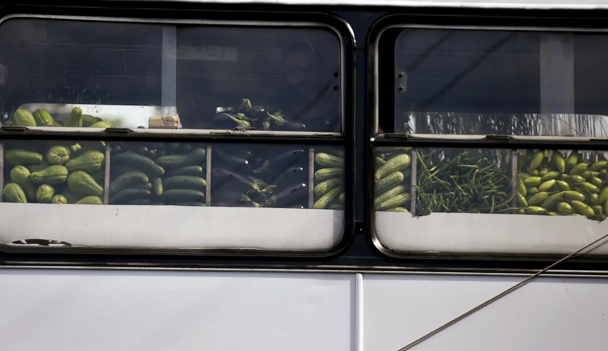 Seorang pria melihat beberapa buah-buahan saat berbelanja di dalam pasar bus 'Sacolao' di Santa Teresa di Rio de Janeiro, Brasil, Selasa (7/7/2015). Pasar bus ini menjual sayur dan buah-buahan dengan harga yang terjangkau. (REUTERS/Pilar Olivares)