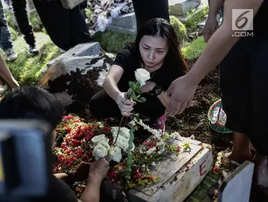 Kekasih almarhum Andika Putra Sahadewa, Nicky Santoso menaruh mawar di makam di TPU Sunan Giri, Rawamangun, Jakarta, Selasa (10/9). Bassist grup band Kerispatih, Andika Putra Sahadewa, meninggal dunia di usia 36 tahun. (Liputan6.com/Faizal Fanani)