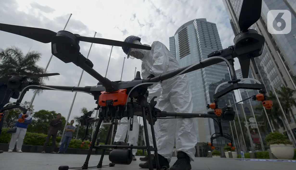 Petugas menyiapkan drone untuk menyemprotkan cairan disinfektan di Jalan Bursa Efek menuju Patung  Pemuda, Jakarta, Jumat (27/3/2020). Penyemprotan dilakukan untuk mencegah penyebaran virus corona COVID-19. (merdeka.com/Imam Buhori)