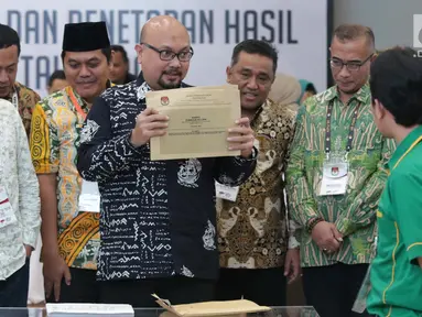 Komisioner KPU RI, Ilham Saputra menunjukkan amplop Formulir DC1-DPR hasil rekap penghitungan suara Provinsi Bali saat rapat Rekapitulasi Hasil Penghitungan Perolehan Suara Tingkat Nasional dan Penetapan Hasil Pemilu Tahun 2019, Jakarta, Jumat (10/5/2019). (Liputan6.com/Helmi Fithriansyah)