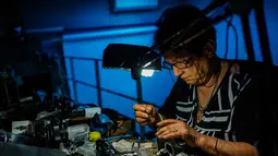 Spesialis reparasi kamera analog, Vessela Draganova sedang bekerja di bengkel kecilnya di Sofia, Bulgaria, Selasa (24/4). Vessela Draganova adalah salah satu spesialis terakhir yang memperbaiki kamera analog di Bulgaria. (AFP PHOTO/Dimitar DILKOFF)
