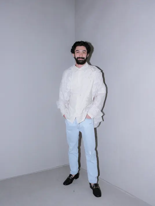 Reza Rahadian tampil simpel menawan dengan atasan lengan panjang berwarna putih dan celana jeans. [Foto: Document/FIMELA]