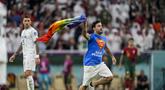 Seorang pria membawa bendera pelangi berlari melintasi lapangan selama pertandingan grup H Piala Dunia 2022 Qatar antara Portugal melawan Uruguay di Stadion Lusail di Lusail, Qatar, Senin, 28 November 2022. Peristiwa pria mengibarkan bendera LGBT itu terjadi pada babak kedua, tepatnya di menit ke-50-an. (AP Photo/Abbie Parr)