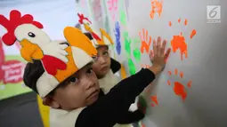 Anak-anak memberikan cap tangan yang dibaluri cat pada Festival Gizi Anak yang digelar Danone Nutricia, Bogor, Selasa (30/1). Kegiatan edukasi gizi ini digelar dalam rangka Hari Raya Gizi Nasional yang jatuh pada 25 Januari 2018 lalu. (Liputan6.com)