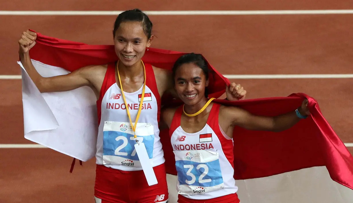 Selebrasi putri Indonesia, Rini Budiarti (kiri) yang meraih medali perak dan Triyaningsih meraih emas nomor lari 5.000m SEA Games 2015. (Bola.com/Arief Bagus)