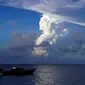 Foto diambil pada 21 Desember 2021 menunjukkan awan gas putih naik dari letusan Hunga Ha'apai terlihat dari garis pantai Patangata dekat ibu kota Tonga, Nuku'alofa. (MARY LYN FONUA / AFP)