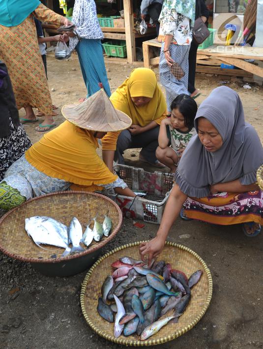 Pedagang ikan melayani pembeli di kawasan Pasar Sumur Jaya, Pandeglang, Banten, Sabtu (3/8/2019). Hingga saat ini tidak ada kerusakan yang berarti di kawasan Kecamatan Sumur usai gempa bermagnitudo 6,9 mengguncang Banten. (merdeka.com/Arie Basuki)