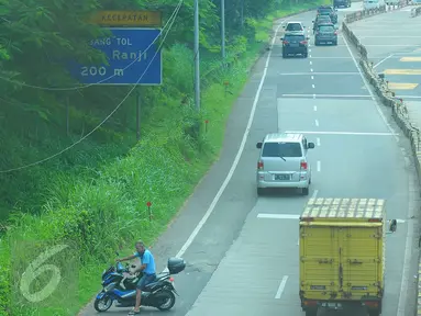 Pengendara motor berusaha memutar arah setelah memasuki Tol Ulujami - Serpong, Tangerang Selatan, Jumat (14/4). Minimnya rambu dan penjagaan petugas, membuat pengendara motor tersebut terjebak masuk ke jalur menuju pintu Tol. (Liputan6.com/Helmi Afandi)