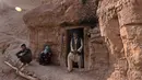 Sebuah keluarga terlihat berada di pintu masuk gua di kota Bamiyan, Kabul. Foto diambil 19 Juni 2015. Ratusan warga miskin Afghanistan terpaksa menghuni gua-gua tersebut untuk dijadikan rumah karena tak memiliki tempat tinggal. (AFP PHOTO / SHAH Marai) 