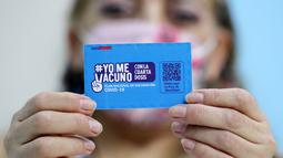 Seseorang menunjukkan kartu vaksinasi COVID-19 di pusat vaksinasi di Santiago, Chile, Senin (10/1/2022). Chile mulai memberikan dosis keempat vaksin COVID-19 kepada warga berusia di atas 12 tahun yang mengalami gangguan kekebalan. (Javier TORRES / AFP)