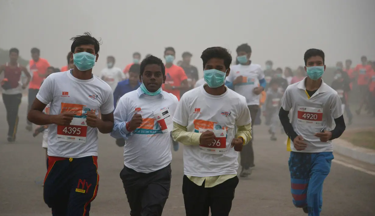 Peserta lari New Delhi 10K menggunakan masker tetap mengikuti lomba ditengah-tengah kabut polusi yang menimpa kota New Delhi, India (6/11). Kabut asap ini diklaim sebagai kabut terparah yang dialami oleh New Delhi dalam 17 tahun. (AFP/Dominique Faget)
