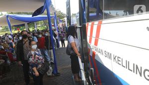 Warga mengantre untuk pembuatan dan memperpanjang SIM di mobil layanan SIM Keliling Masjid At-Tin TMII, Jakarta Timur, Kamis (4/6/2020). Direktorat Lalu Lintas Polda Metro Jaya mengoperasikan kembali layanan mobil SIM Keliling untuk mengantisipasi antrean pemohon. (Liputan6.com/Herman Zakharia)