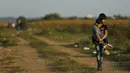 Seorang imigran remaja menggendong adiknya melintasi perbatasan dari Serbia ke Kroasia di Tovarnik (18/9/2015). (REUTERS / Antonio Bronic)