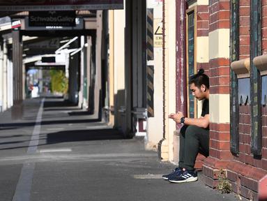 Seorang pekerja beristirahat di sebuah kafe yang biasanya ramai saat kota itu mengalami penguncian keenam saat memerangi wabah varian Delta dari coronavirus di Melbourne (25/8/2021). (AFP/William West)