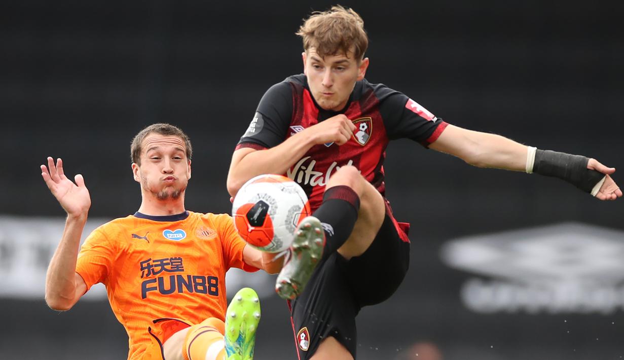 Gelandang Newcastle United, Javier Manquillo, berebut bola dengan gelandang Bournemouth, David Brooks, pada laga lanjutan Premier League pekan ke-32 di Vitality Stadium, Kamis (2/7/2020) dini hari WIB. Newcastle menang 4-1 atas Bournemouth. (AFP/Peter Cziborra/pool)
