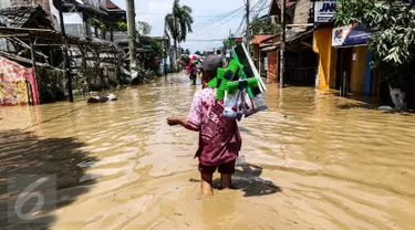 Pedagang alat kebersihan menerobos banjir di kompleks Pondok Gede Permai, Jatiasih, Bekasi, Jumat (22/4). Mereka menjajakan dagangannya berupa alat kebersihan ketika banjir di  kawasan tersebut mulai surut. (Liputan6.com/Fery Pradolo)