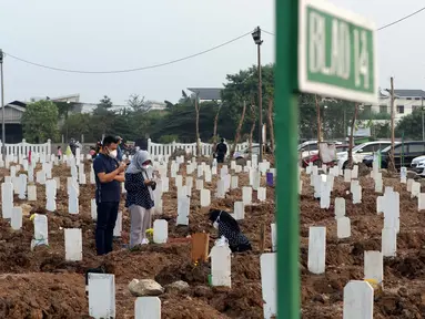 Warga saat melakukan ziarah di pemakaman khusus COVID-19 TPU Rorotan, Cilincing, Jakarta, Sabtu (31/7/2021). Warga yang melakukan ziarah diwajibkan mematuhi protokol kesehatan, menjaga jarak serta dilakukan secara terbatas. (Liputan6.com/Helmi Fithriansyah)