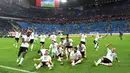 Pemain Jerman berlari menuju piala saat merayakan kemenangannya dalam final Piala Konfederasi 2017 di Stadion Saint Petersburg, Rusia (2/7). Gol tunggal tersebut berhasil dicetak oleh pemain Jerman, Lars Stindl. (AFP Photo/Kirill Kudryavtsev)