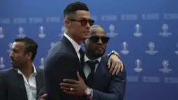 Penyerang Juventus, Cristiano Ronaldo memeluk mantan bek MU Patrice Evra saat menghadiri acara undian penyisihan grup Liga Champions UEFA dan pemain terbaik Eropa di Forum Grimaldi, Monaco (29/8/2019). (AP Photo/Daniel Cole)