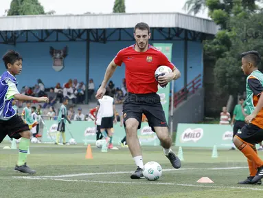Pelatih FCBEscola, Aldric Miro, saat memberikan pelatihan MILO Football Clinic Day di Lapangan Simprug, Jakarta, Sabtu (16/12/2017). Sebanyak 500 anak mendapatkan pelatihan dasar teknik sepak bola dari pelatih berpengalaman. (Bola.com/M Iqbal Ichsan)