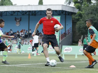 Pelatih FCBEscola, Aldric Miro, saat memberikan pelatihan MILO Football Clinic Day di Lapangan Simprug, Jakarta, Sabtu (16/12/2017). Sebanyak 500 anak mendapatkan pelatihan dasar teknik sepak bola dari pelatih berpengalaman. (Bola.com/M Iqbal Ichsan)