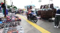 Pengendara motor melintas diatas trotoar yang samping kanan-kirinya dipenuhi pedagang kaki lima di Jalan Kebon Jati, Tanah abang, Sabtu (23/12). (Liputan6.com/Angga Yuniar)