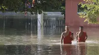 Biksu Buddha berjalan melewati pagoda yang banjir setelah hujan turun di Phnom Penh, Kamboja (14 /10/2020). Pejabat bencana Kamboja mengatakan Rabu bahwa lebih dari 10.000 orang telah dievakuasi ke tempat aman setelah badai tropis melanda yang menyebabkan banjir bandang.  (AP Photo/Heng Sinith)