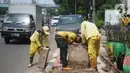 Petugas Bina Marga memerlebar saluran air di Jalan TB Simatupang di kawasan Cilandak, Jakarta, Kamis (22/10/2020). Hal tersebut dilakukan guna memaksimalkan fungsi sistem drainase agar tidak terjadi genangan air saat menghadapi musim hujan. (Liputan6.com/Immanuel Antonius)