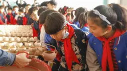 Sejumlah siswa sekolah dasar melihat proses pembuatan porselen di bengkel kerja porselen Ru di Baofeng, Provinsi Henan, China, 15 November 2020. Lebih dari 90 siswa SD Xichengmen mengikuti kegiatan praktik di bengkel kerja itu untuk belajar tentang porselen Ru. (Xinhua/He Wuchang)