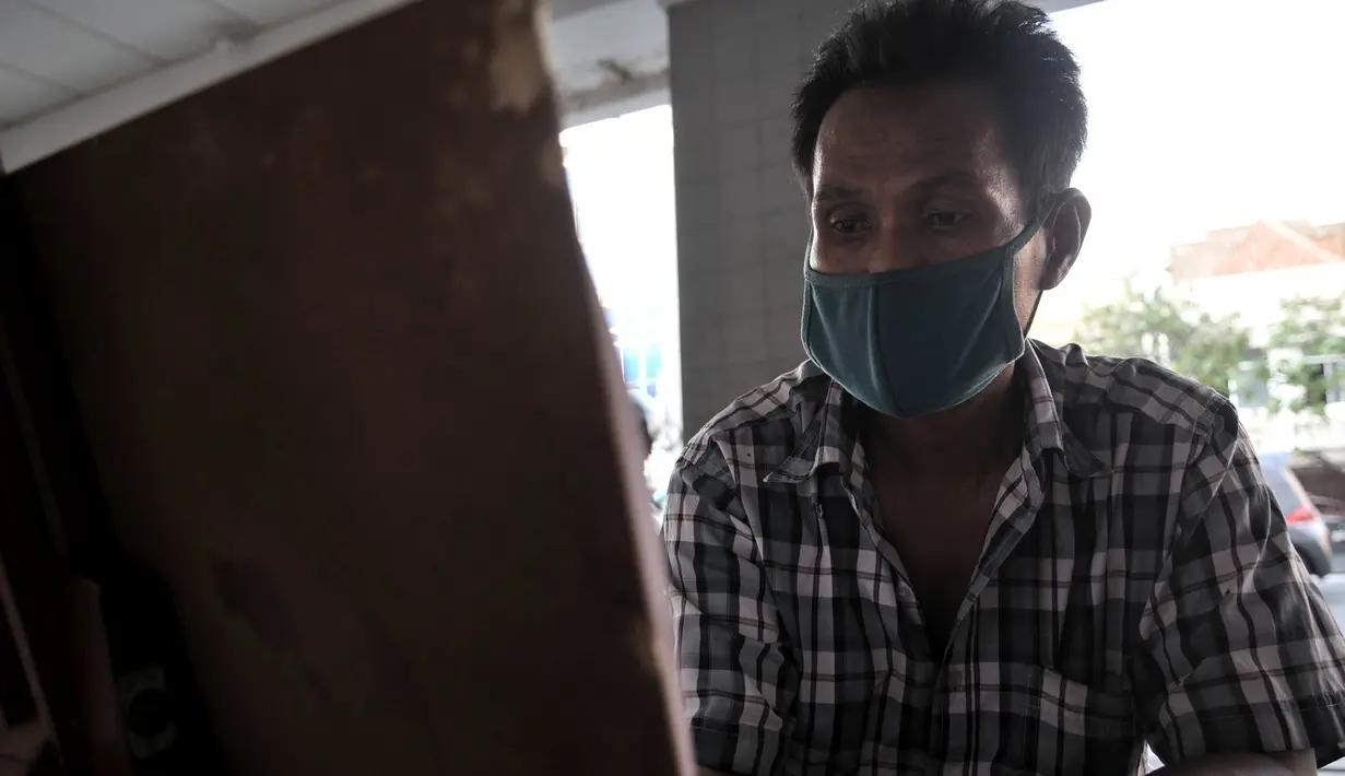 Seniman lukis menyelesaikan karyanya di pinggir Jalan Pintu Besar Selatan, Pinangsia, Jakarta, Selasa (2/6/2020). Pandemi virus corona COVID-19 ditambah adanya PSBB mengakibatkan penghasilan para pelukis di kawasan Kota Tua tersebut turun hingga 80 persen. (merdeka.com/Iqbal S. Nugroho)