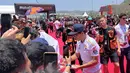 Pembalap Repsol Honda, Marc Marquez (kanan), membubuhkan tanda tangan saat menyapa penggemar dalam kegiatan MotoGP Hero Walk di Sirkuit Mandalika, Lombok , Minggu (15/10/2023). (Bola.com/Benediktus Gerendo Pradigdo)