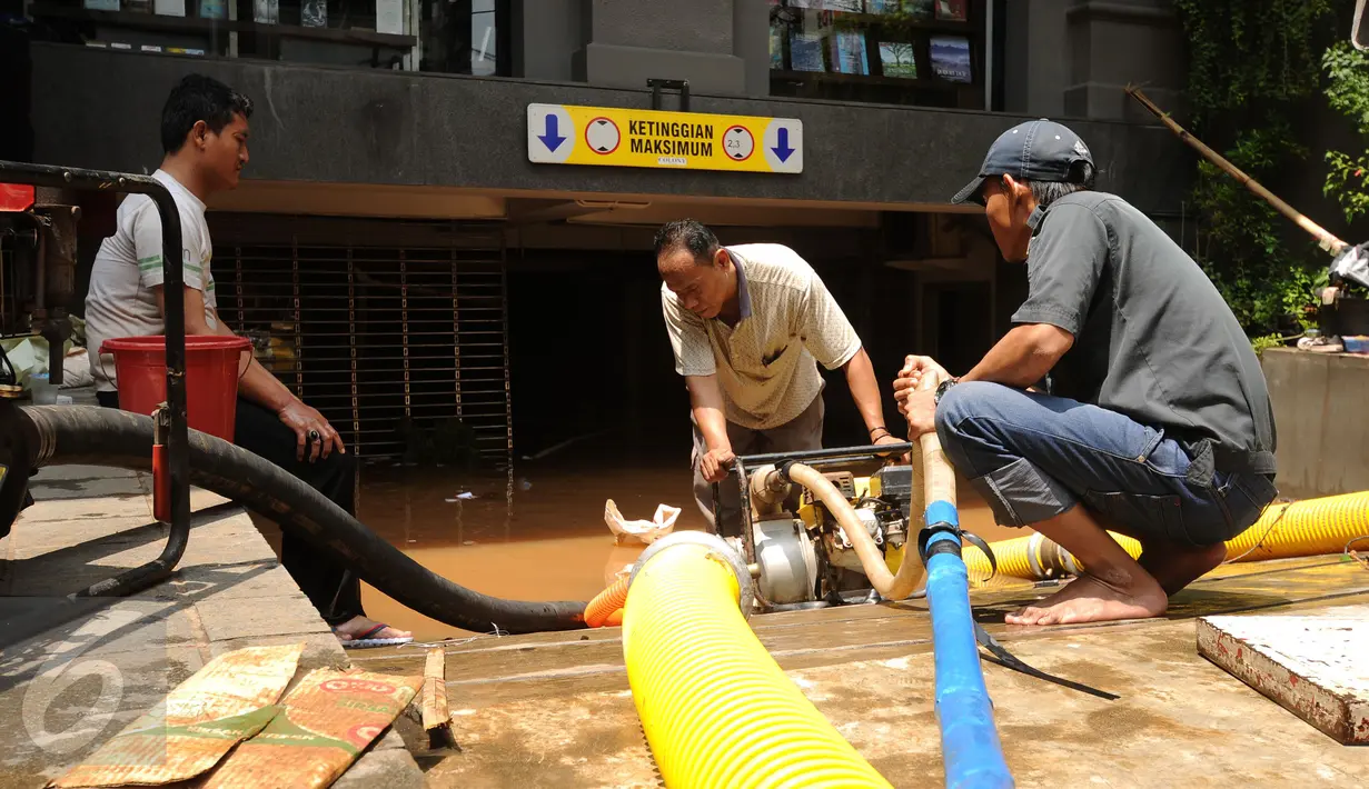 Petugas memasang mesin penyedot air saat melakukan pengeringan di salah satu pertokoan di Jalan Kemang Raya, Jakarta, Minggu (28/8). Dua lokasi parkir bawah tanah pertokoan di kawasan Kemang terendam air. (Liputan6.com/Helmi Fithriansyah)