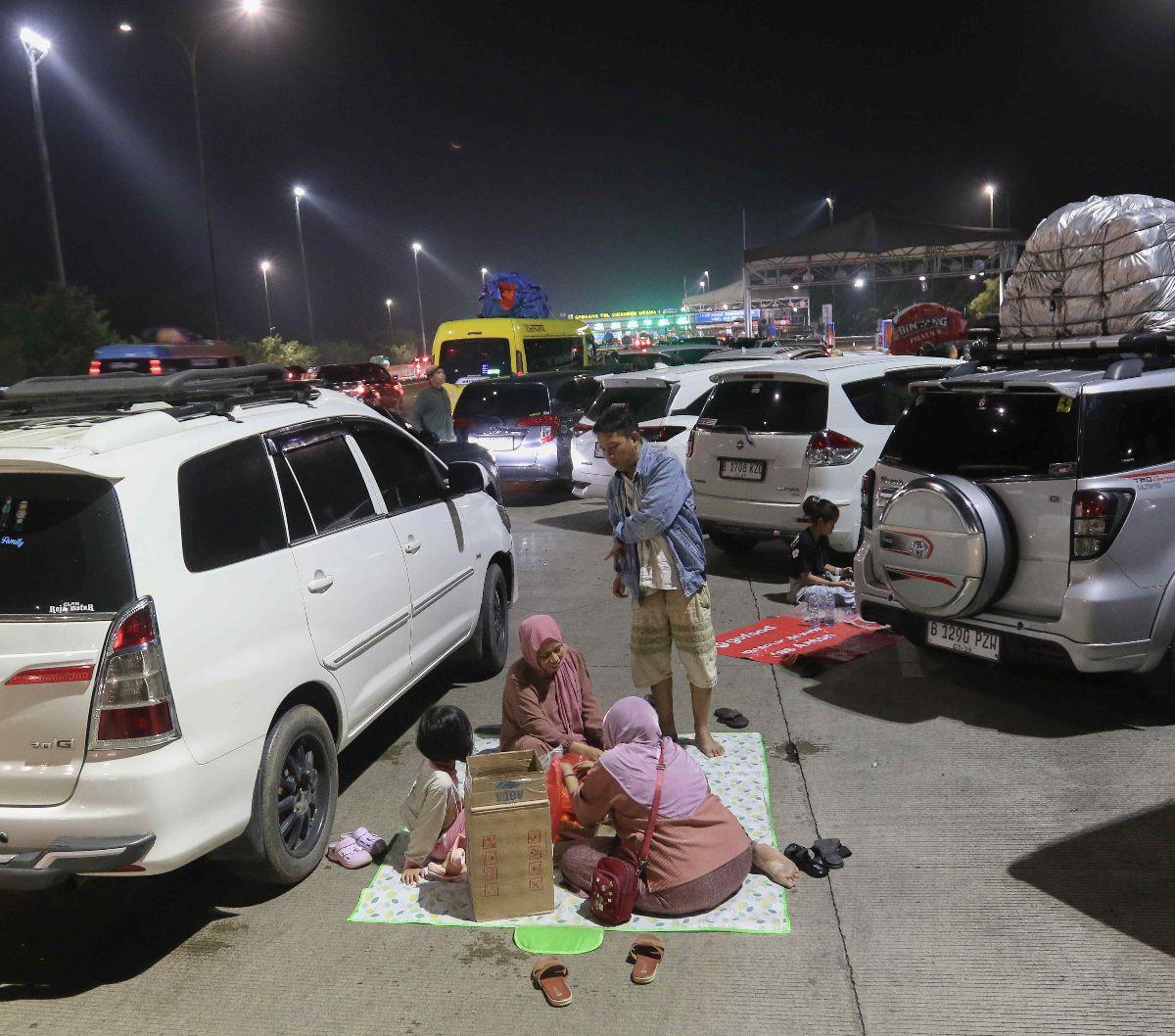 Sejumlah pemudik menggelar tikar saat menikmati makan sahur di dekat Gerbang Tol Cikampek Utama, Cikampek, Jawa Barat, Sabtu (6/4/2024). Arus mudik Lebaran 2024 telah dimulai. Berbagai pemandangan menarik terekam dalam perjalanan warga ketika menuju ke ka