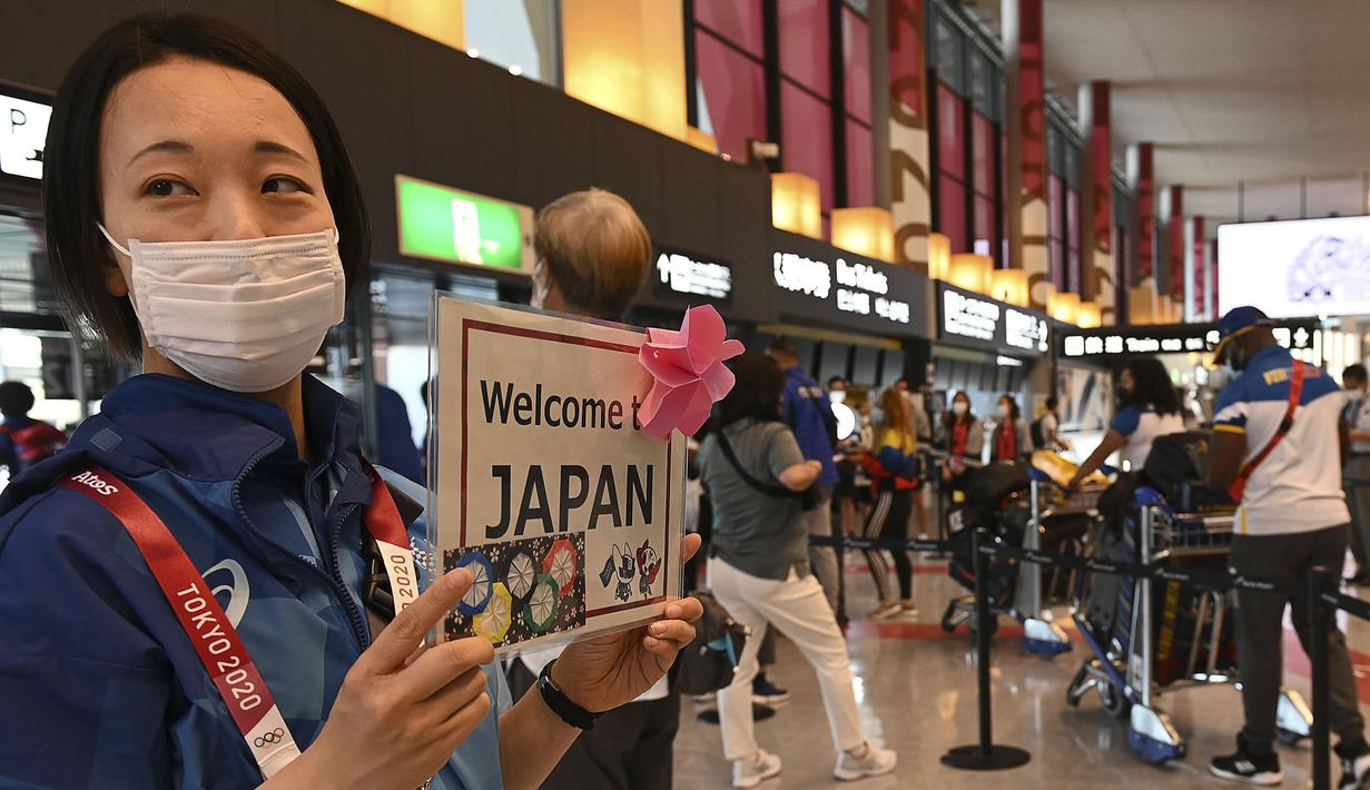 Seorang relawan menyambut delegasi Olimpiade di Bandara Internasional Narita, Prefektur Chiba pada 20 Juli 2021 untuk mengikuti Olimpiade Tokyo 2020 mendatang. (AFP/Kazuhiro Nogi)