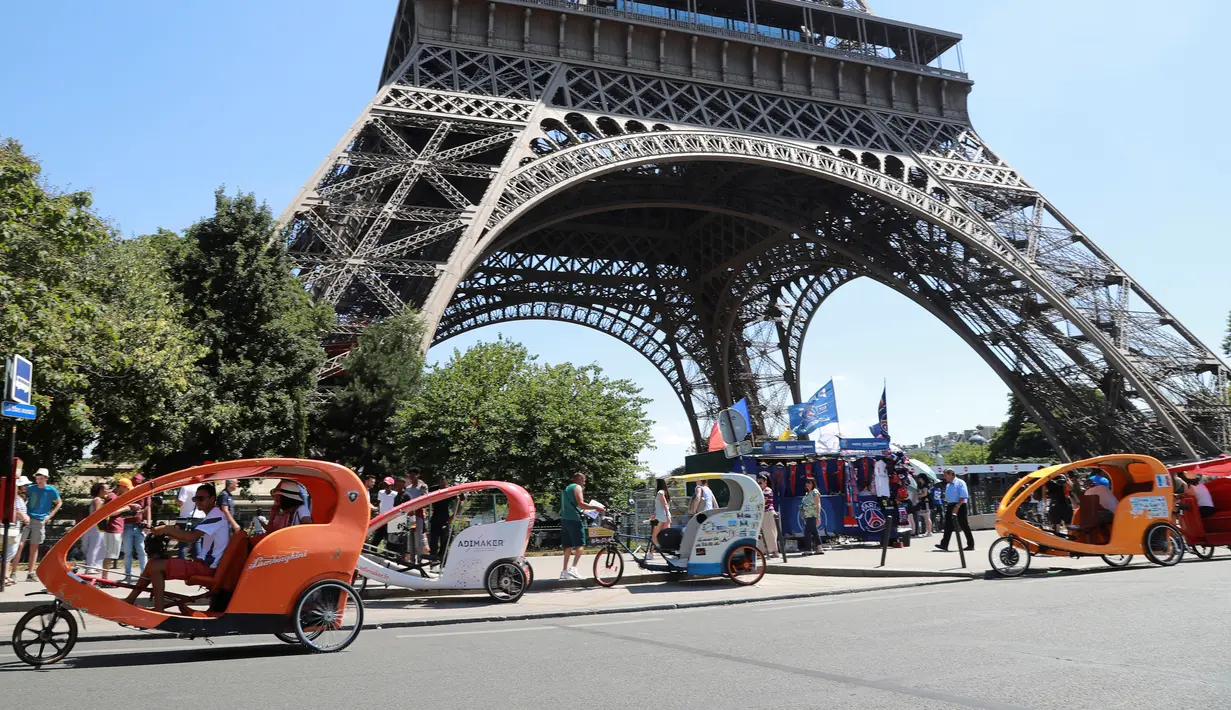 Sejumlah pengendara becak menunggu wisatawan di sekitaran Menara Eiffel, Kota Paris, Prancis,  (7/7). Menurut media setempat, kemunculan becak ini membuat para sopir taksi memiliki saingan. (AFP Photo/Jacques Demarthon)