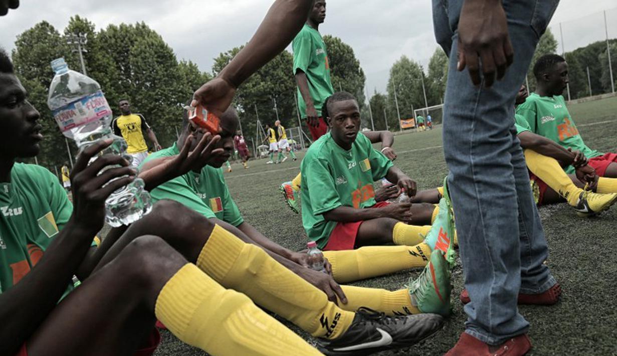 Pemain Mali saat jeda pertandingan melawan Guinea dalam turnamen sepak bola untuk kaum migran dan orang asing bertajuk "Balon Mundial" yang dihelat 6 Juni-5 Juli 2015 di Turin, Italia. (AFP PHOTO/MARCO BERTORELLO)