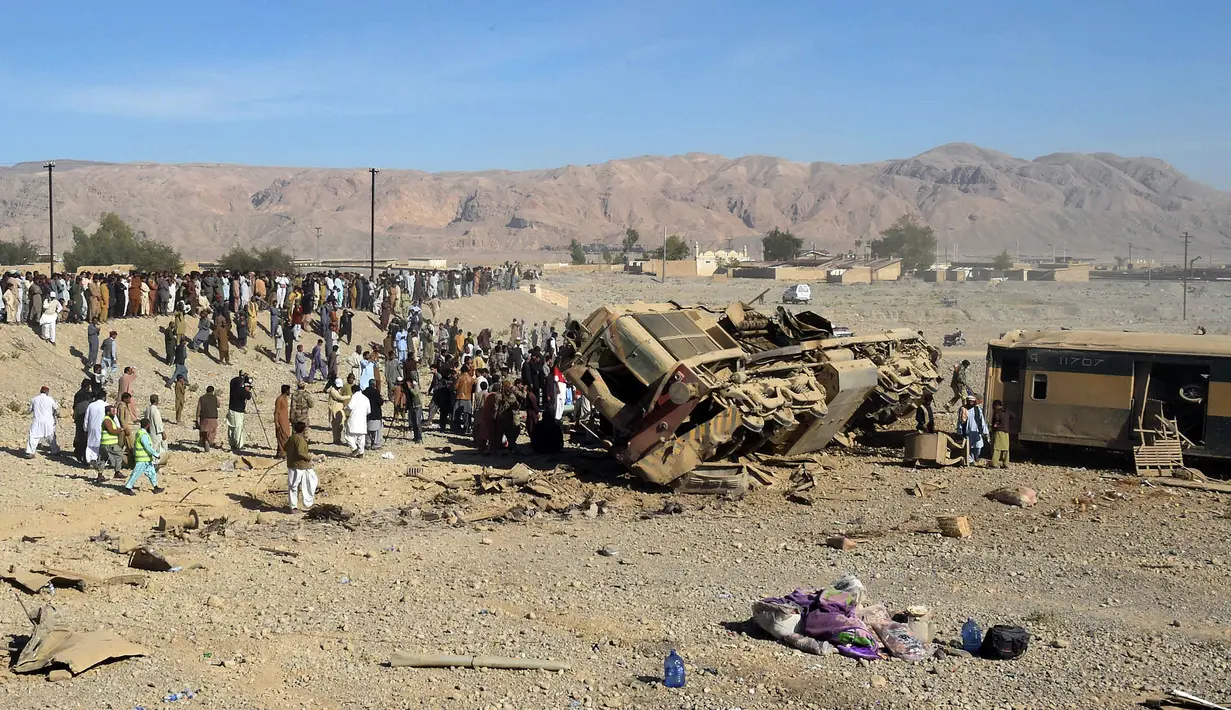 Sejumlah orang berkumpul di lokasi kereta api yang tergelincir dari rel di daerah pegunungan Bolan dekat Quetta dalam perjalanan ke Rawalpindi, Pakistan, Selasa (17/11). 12 orang tewas dan ratusan terluka dalam kecelakaan tersebut (AFP PHOTO/BANARAS KHAN)