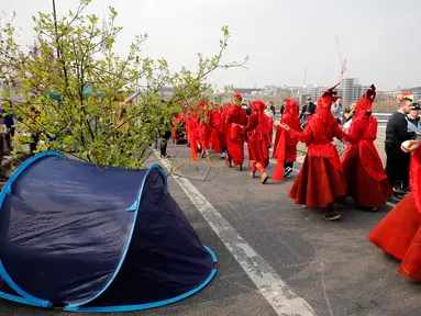 Aktivis lingkungan saat melakukan blokade Jembatan Waterloo, London, Inggris (17/4). Aksi blokade ini untuk mendorong pemerintah berbuat lebih dalam mengatasi perubahan iklim yang terjadi. (AFP Photo/Tolga Akmen)