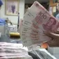 Seorang teller menunjukan  mata uang Yuan di Jakarta, Senin (30/11). Dana Moneter Internasional (IMF), Senin (30/11), resmi memasukan yuan, atau renminbi, ke dalam special drawing rights (SDR) sebagai mata uang elite dunia. (Liputan6.com/Angga Yuniar)