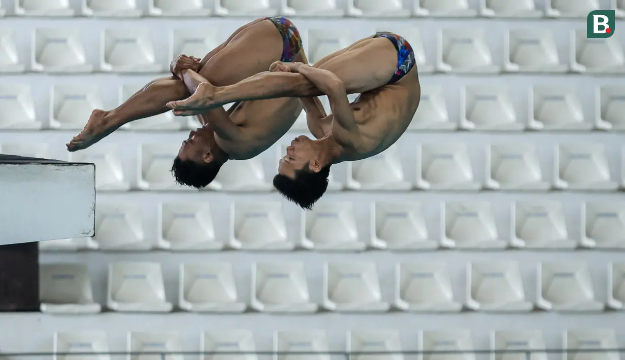 Pasangan atlet loncat indah, Andriyan (kanan) dan Adityo Restu Putra beraksi pada nomor menara synchro putra Kejurnas Akuatik 2026 di Stadion Akuatik Gelora Bung Karno, Senayan, Jakarta, Selasa (05/05/2026). (Bola.com/Bagaskara Lazuardi)