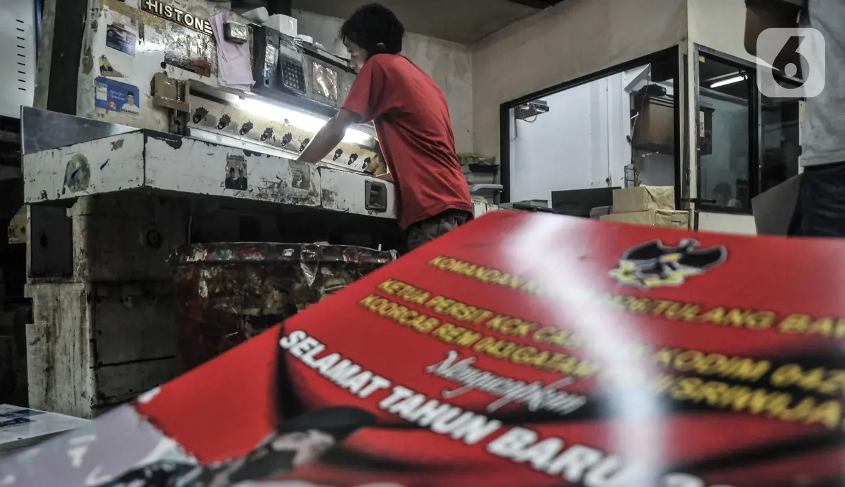 Pekerja saat menyelesaikan pembuatan kalender 2022 di toko percetakan kawasan Senen, Jakarta, Senin (27/12/2021). Jelang tahun baru 2022 permintaan kalender meningkat hingga 20 persen dibandingkan tahun sebelumnya. (merdeka.com/Iqbal S Nugroho)