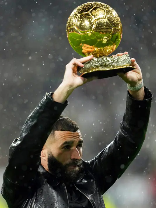 Pemain Real Madrid Karim Benzema memegang trofi Ballon d'Or 2022 sebelum pertandingan sepak bola Liga Spanyol antara Real Madrid dan Sevilla di Stadion Santiago Bernabeu, Madrid, Spanyol, 22 Oktober 2022. Ballon d'Or ini adalah pencapaian terbaik Benzema setelah pada 2021 lalu dirinya menduduki peringkat keempat di bawah Lionel Messi, Robert Lewandowski, dan Jorginho. (AP Photo/Manu Fernandez)